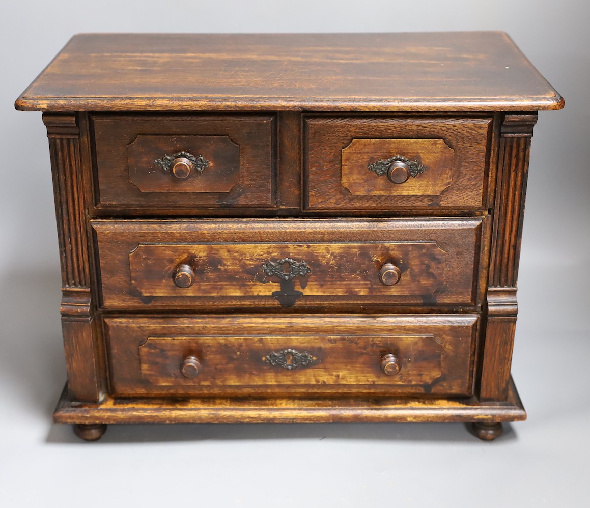 A 19th century miniature oak chest of drawers, 40 cms wide.